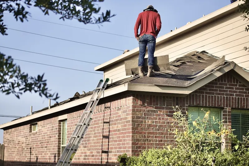 Professional roofer working on a residential roof in Cedars